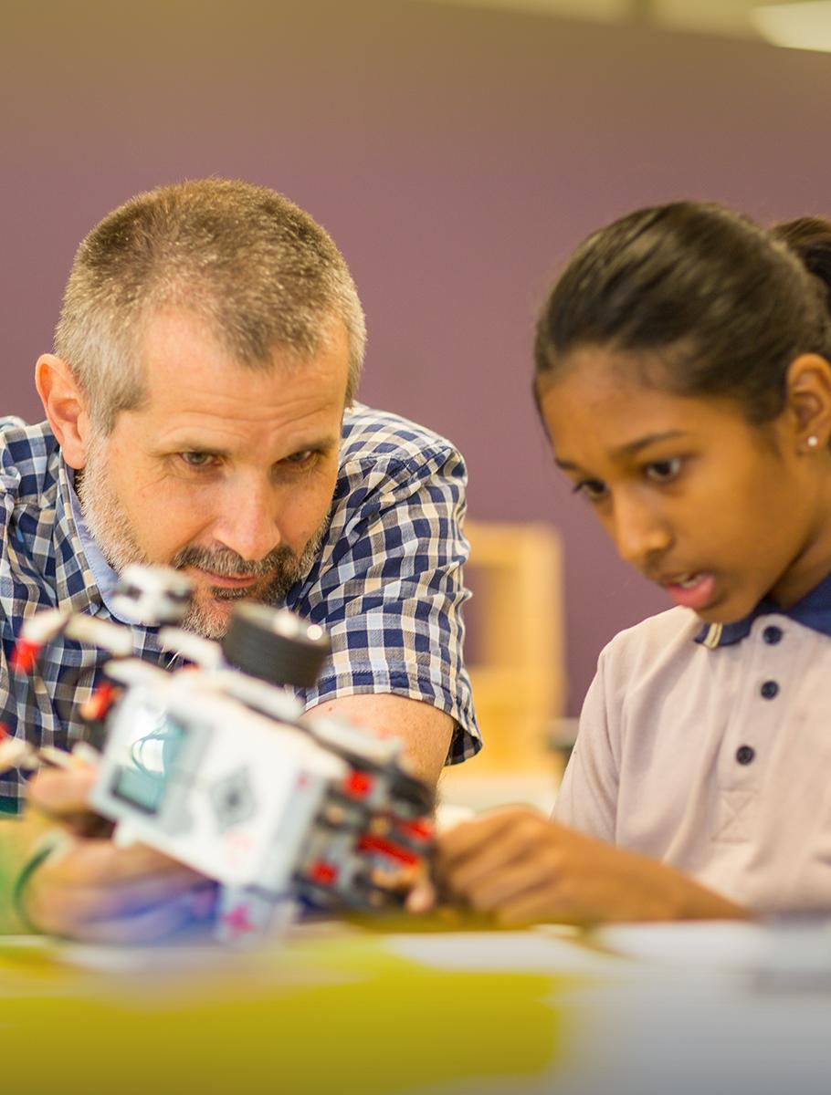 Teacher helping student with robotics